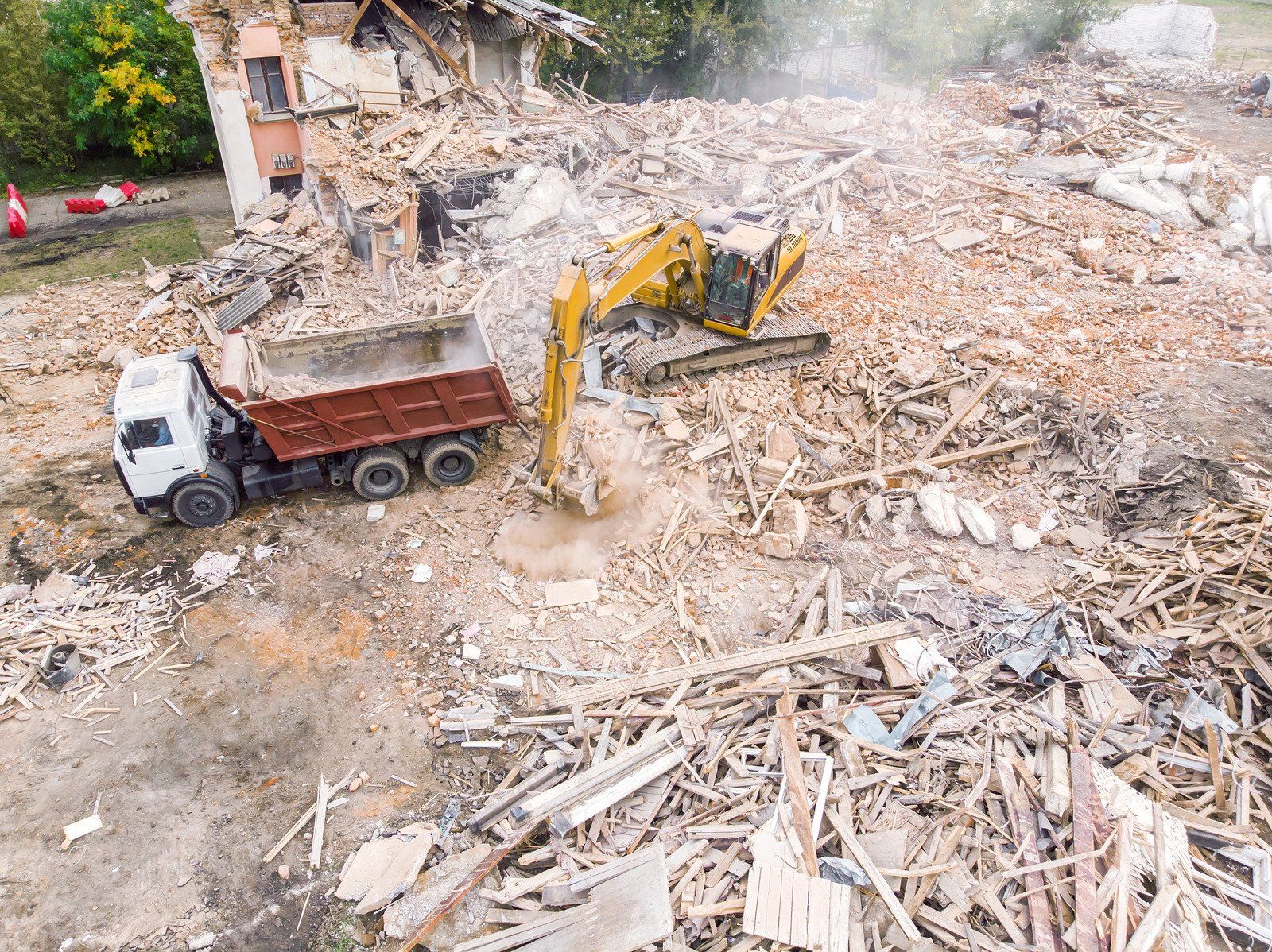 Excavator loading debris into dump truck