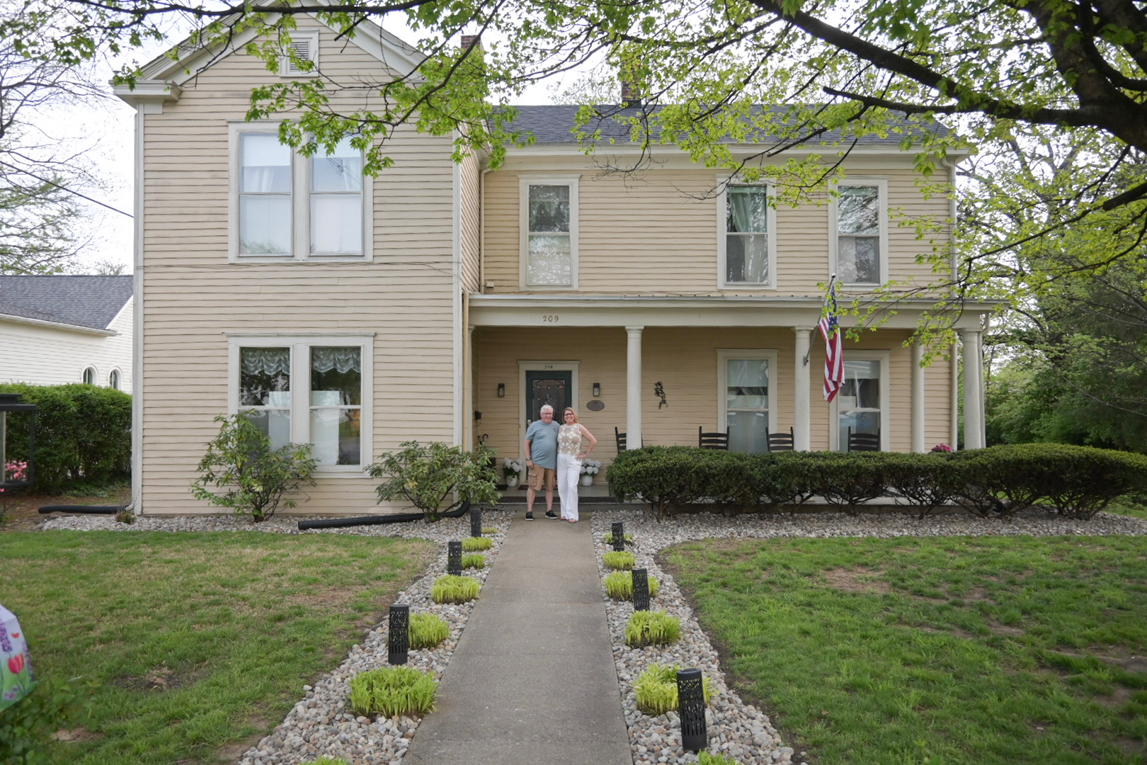 A large house with a porch and an american flag on it
