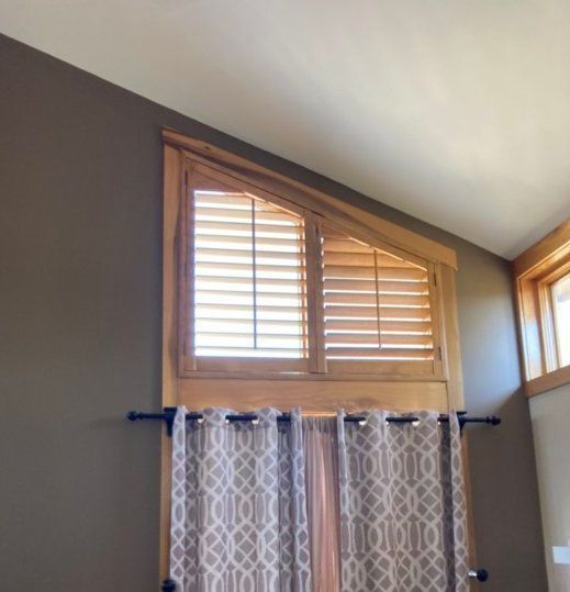 Angled Shutter Lexington, KY A window with shutters and a patterned curtain