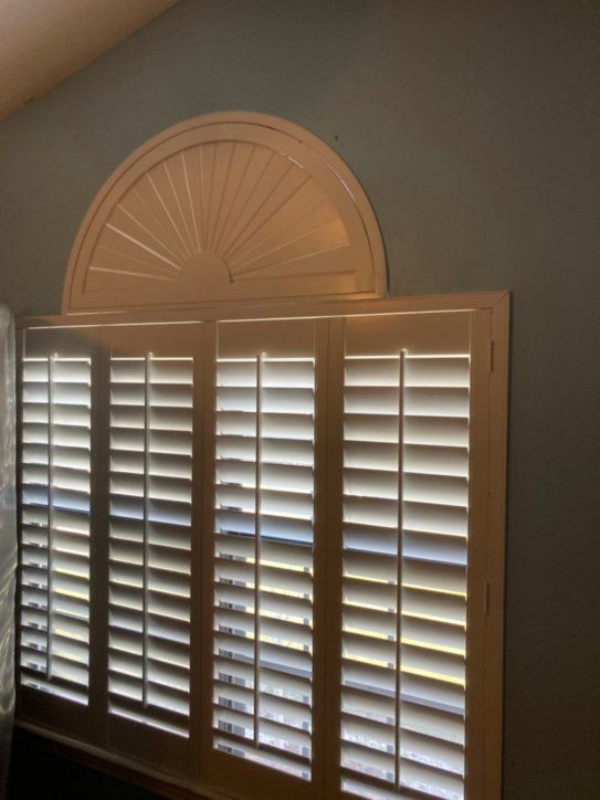 A window with arched shutters on it