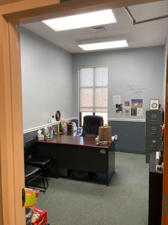 A room with a desk and a chair in it
