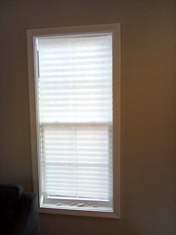 There is a window with blinds on it in a room.