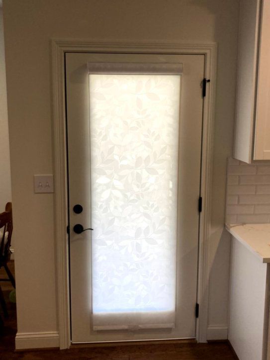 A white door with a white blind on it in a kitchen.
