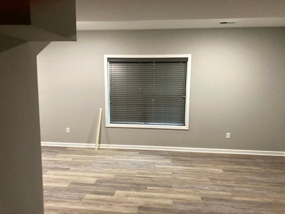 An empty room with a window and blinds.