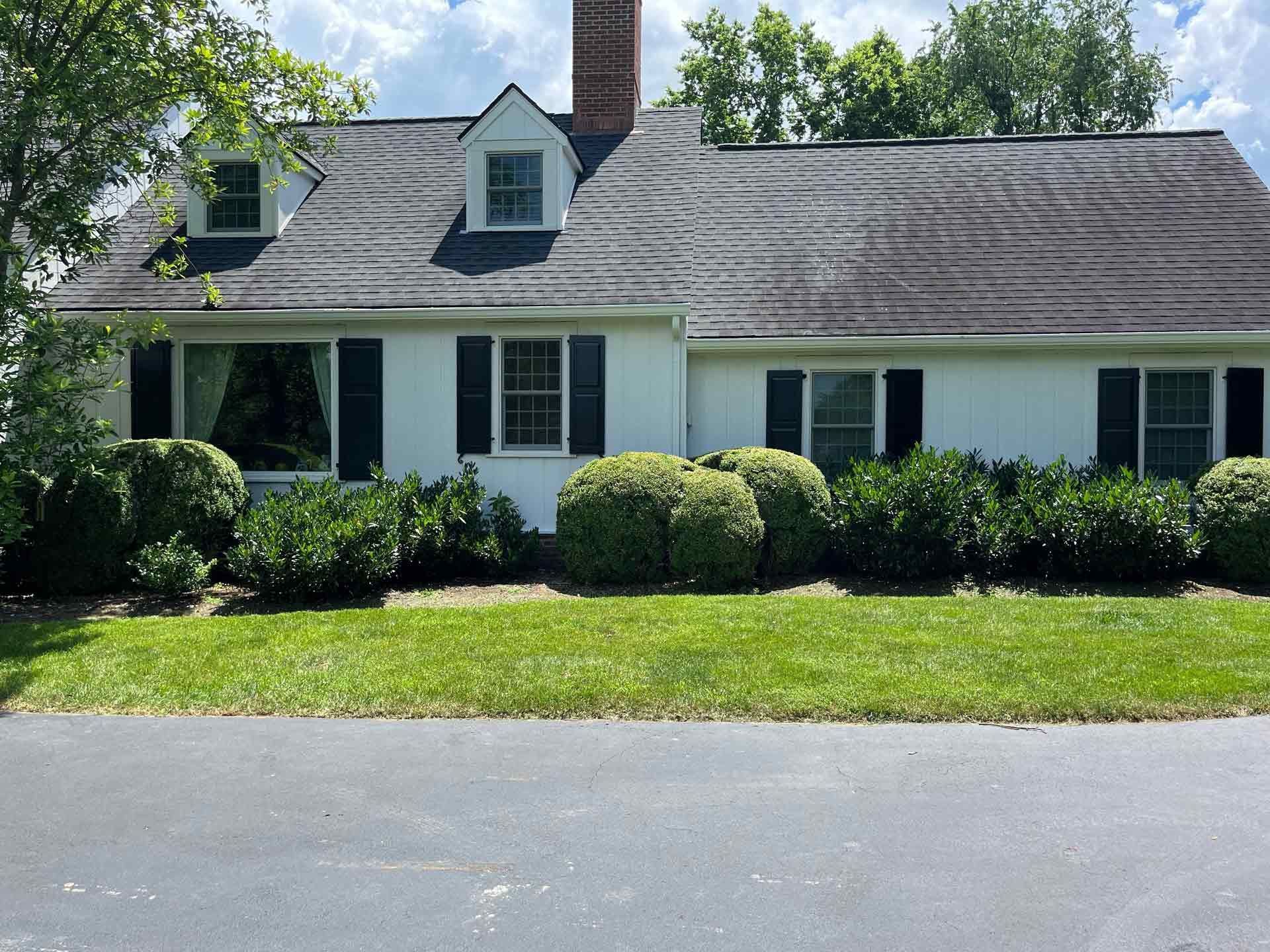 A white house with a black roof and black shutters