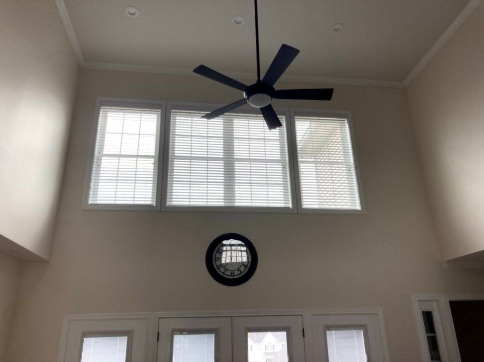 A living room with a ceiling fan and a clock on the wall