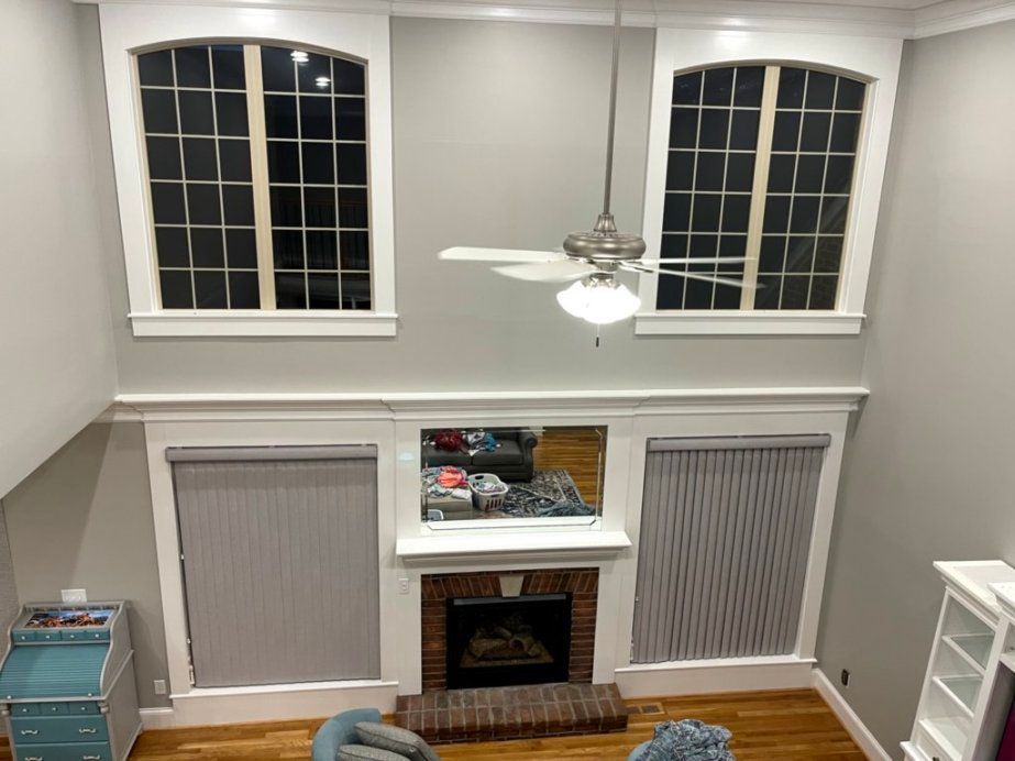 An aerial view of a living room with a fireplace and ceiling fan.