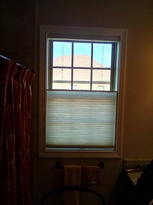 A bathroom with a window and a shower curtain.