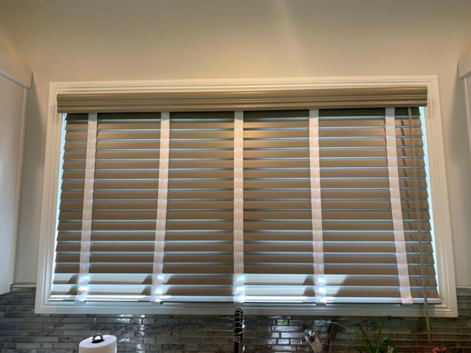 A kitchen window with blinds on it and a sink.