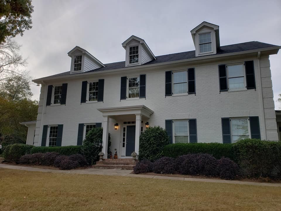 A large white house with black shutters on the windows