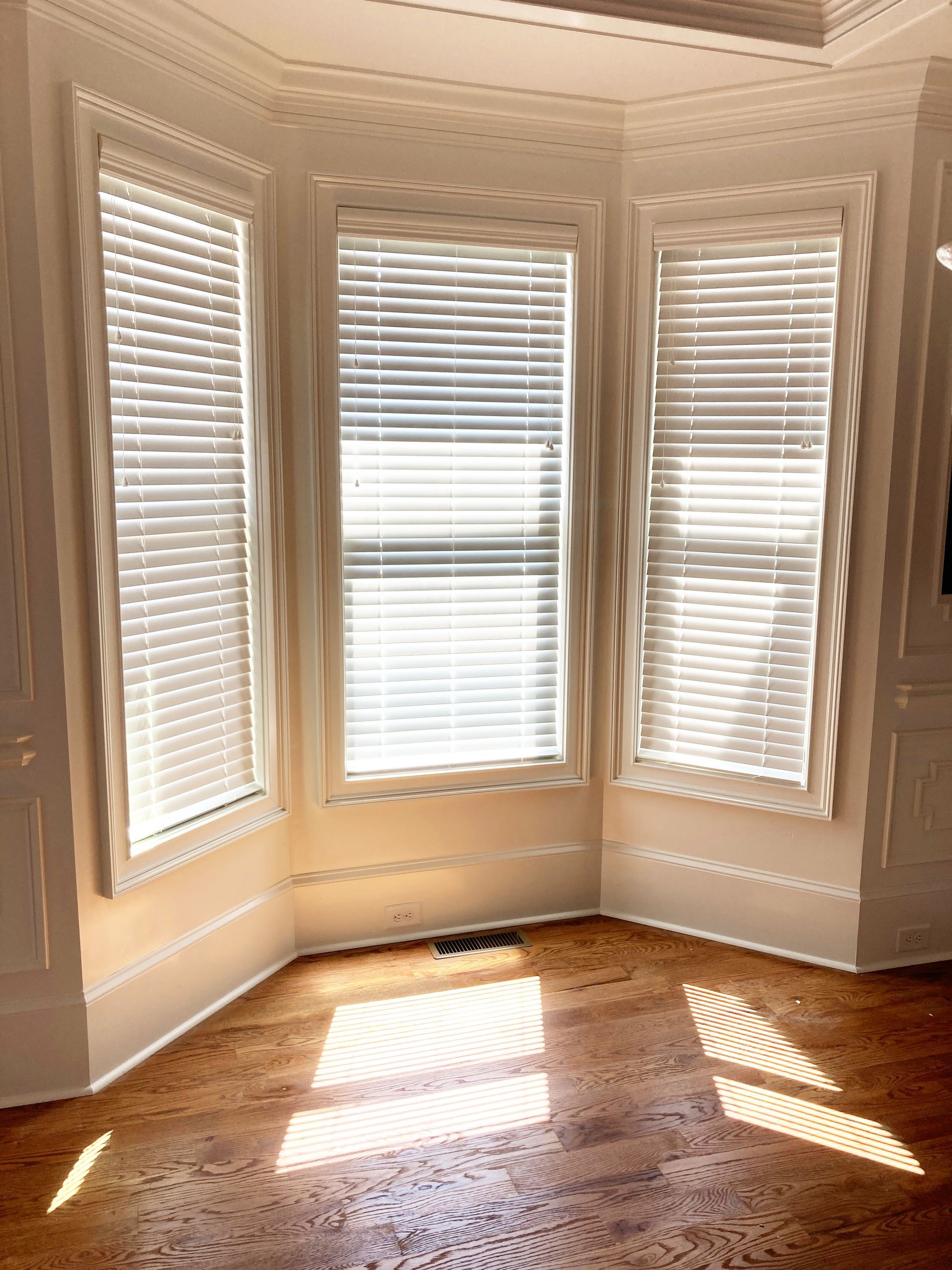 A room with a lot of windows and blinds on the windows.