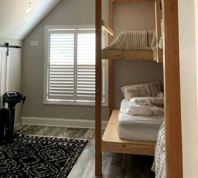 A bedroom with a bunk bed and a window