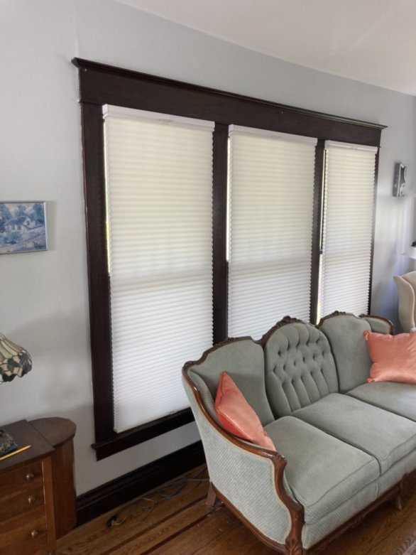 A living room with a couch and a window with blinds