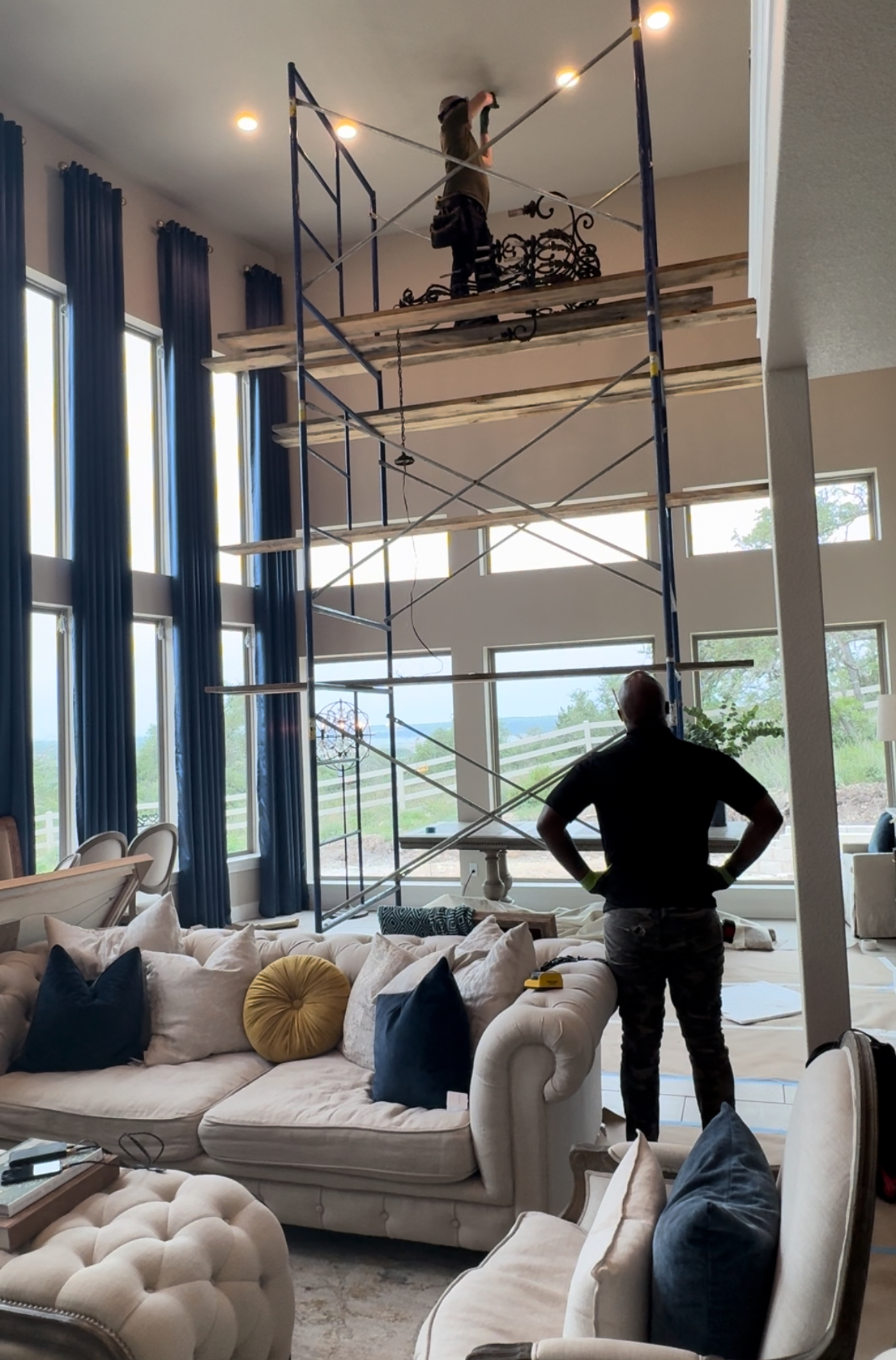 A man standing in a living room with a scaffolding in the background