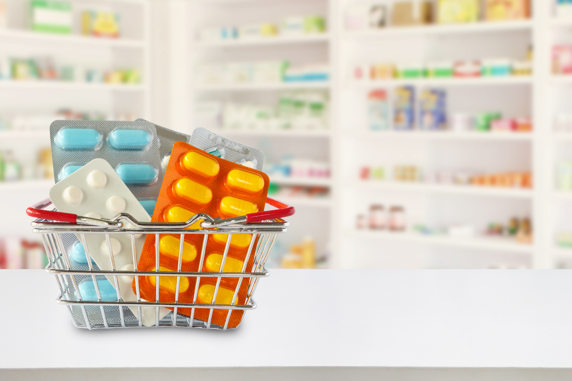 Shopping basket filled with colorful medicine blister packs in a pharmacy aisle