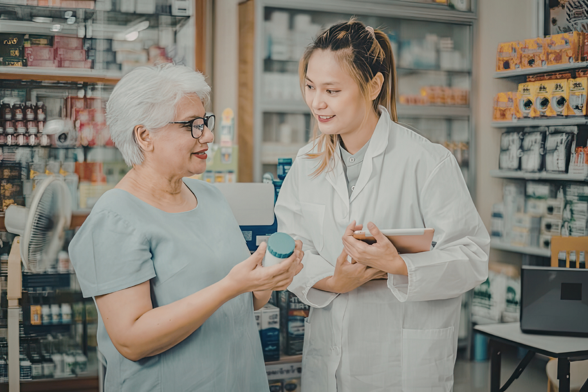 Pharmacist helping a customer in a drugstore, discussing medicine and holding a bottle.