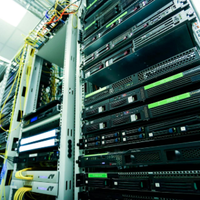 Rows of server racks in a data center with cables and blinking green lights