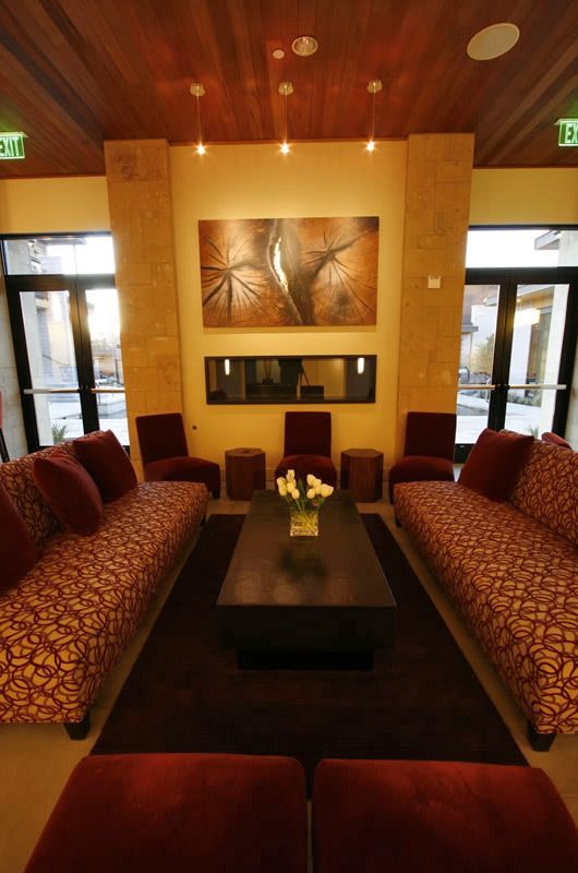 Cozy lounge with two patterned sofas, low table, and fireplace under warm lighting
