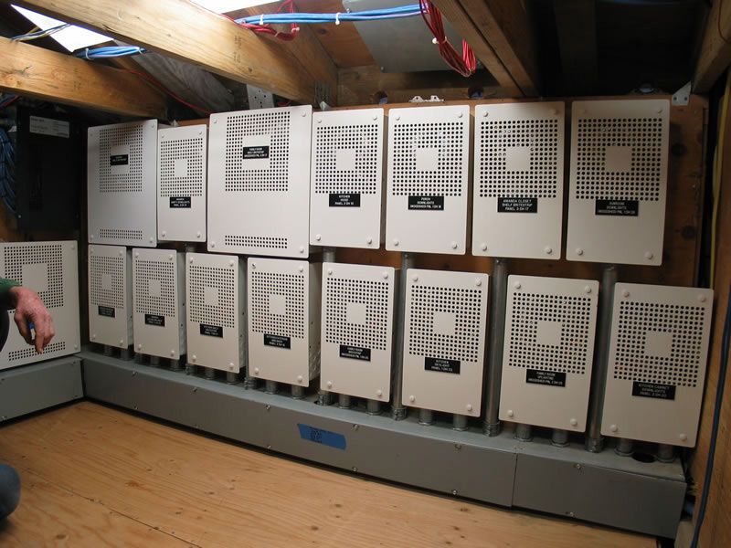 Row of vintage beige computer terminals in a wooden attic room under slanted beams.