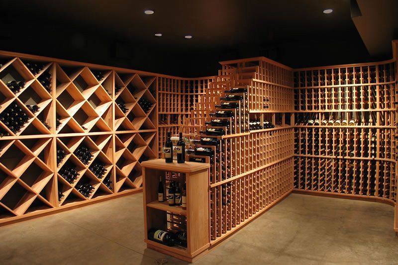 Wooden wine cellar with lattice bottle racks and shelves in warm lighting
