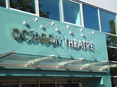 OCTAGON THEATRE sign on a glass building entrance with teal panels