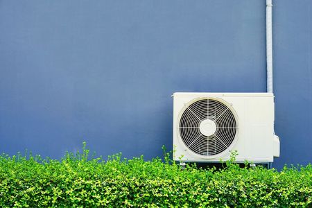 A Close Up of a White Air Conditioner Hanging on a Wall — Air-Con Cleaning Specialists in Redlynch, QLD