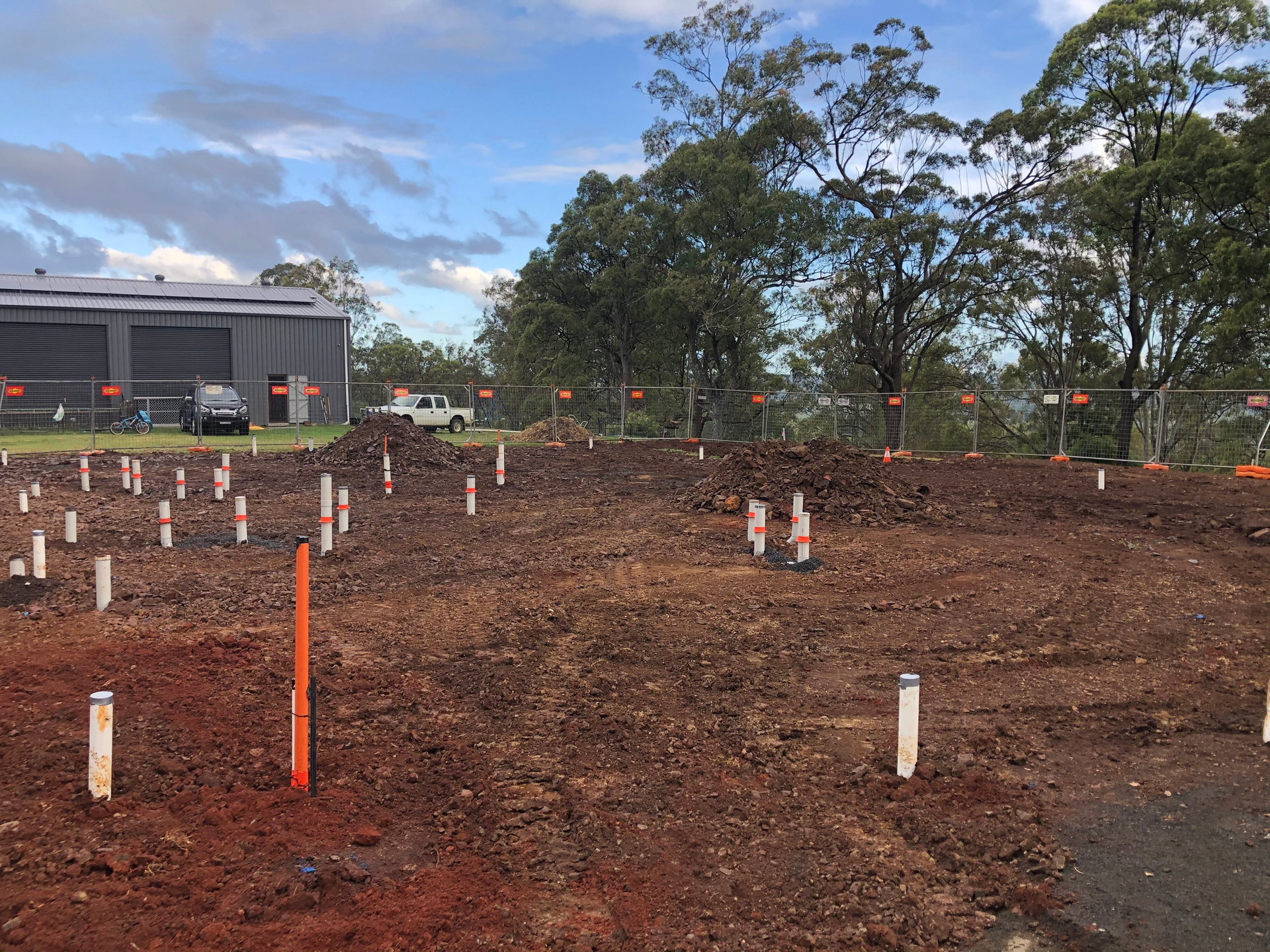 A Large Dirt Field With a Building in the Background — Bevan Plumbing in South Lismore, NSW