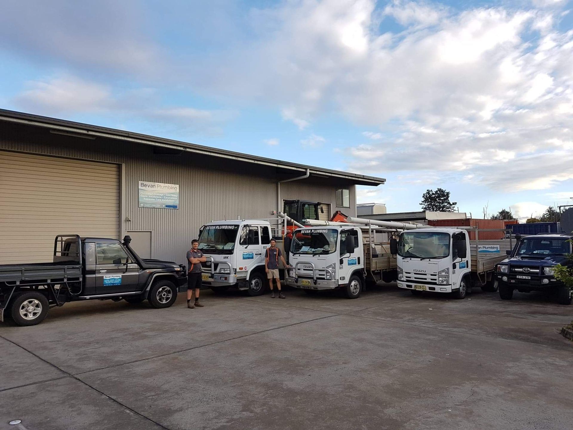 A Group of Trucks Are Parked in Front of a Building — Bevan Plumbing in South Lismore, NSW