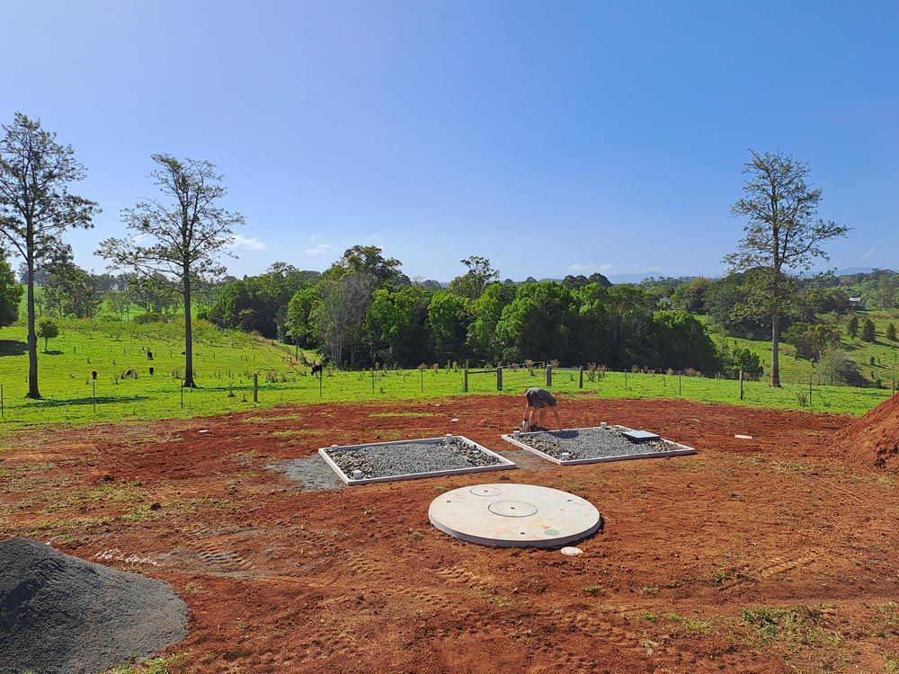 A Manhole Cover is Sitting in the Middle of a Dirt Field — Bevan Plumbing in Kyogle, NSW