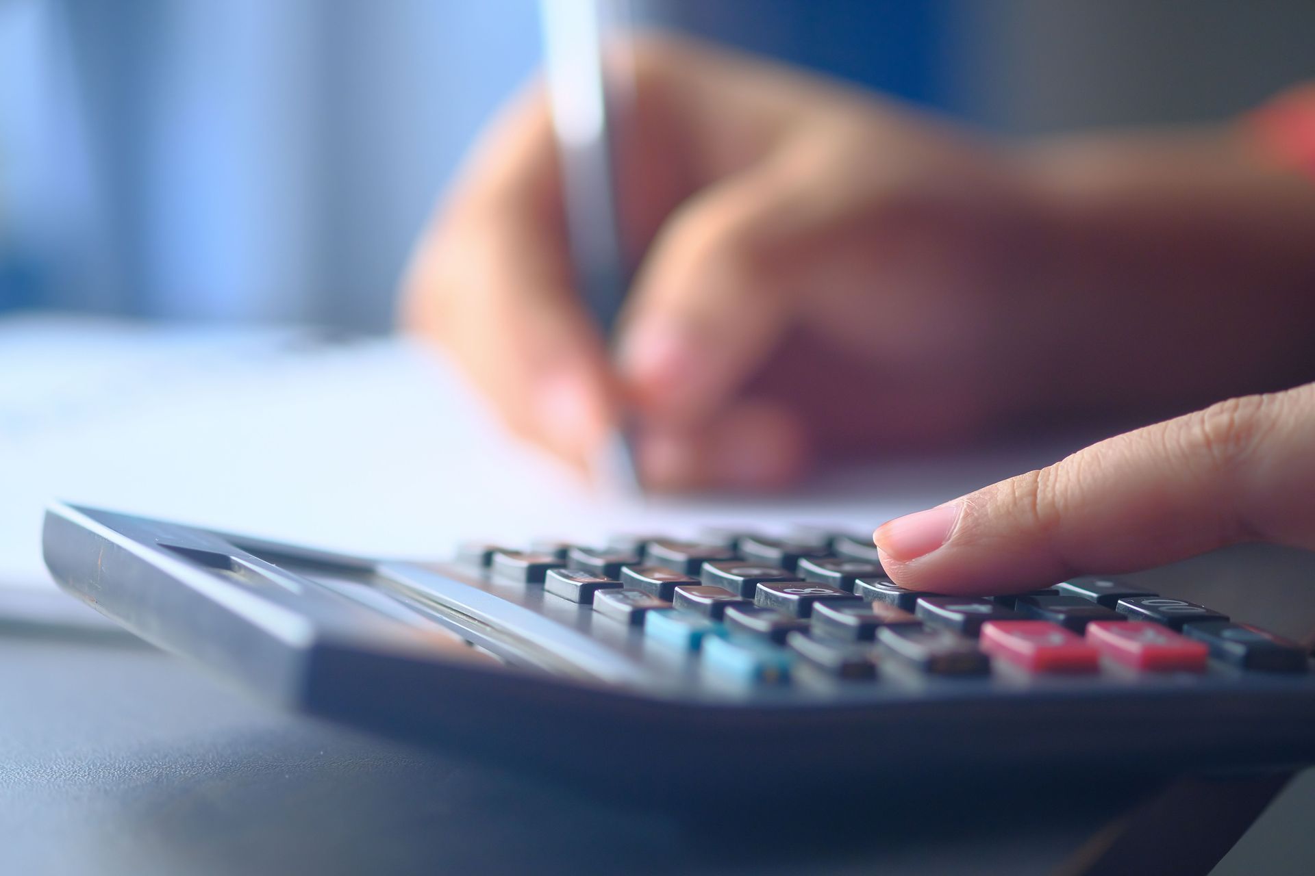 Man using calculator and marking financial documents