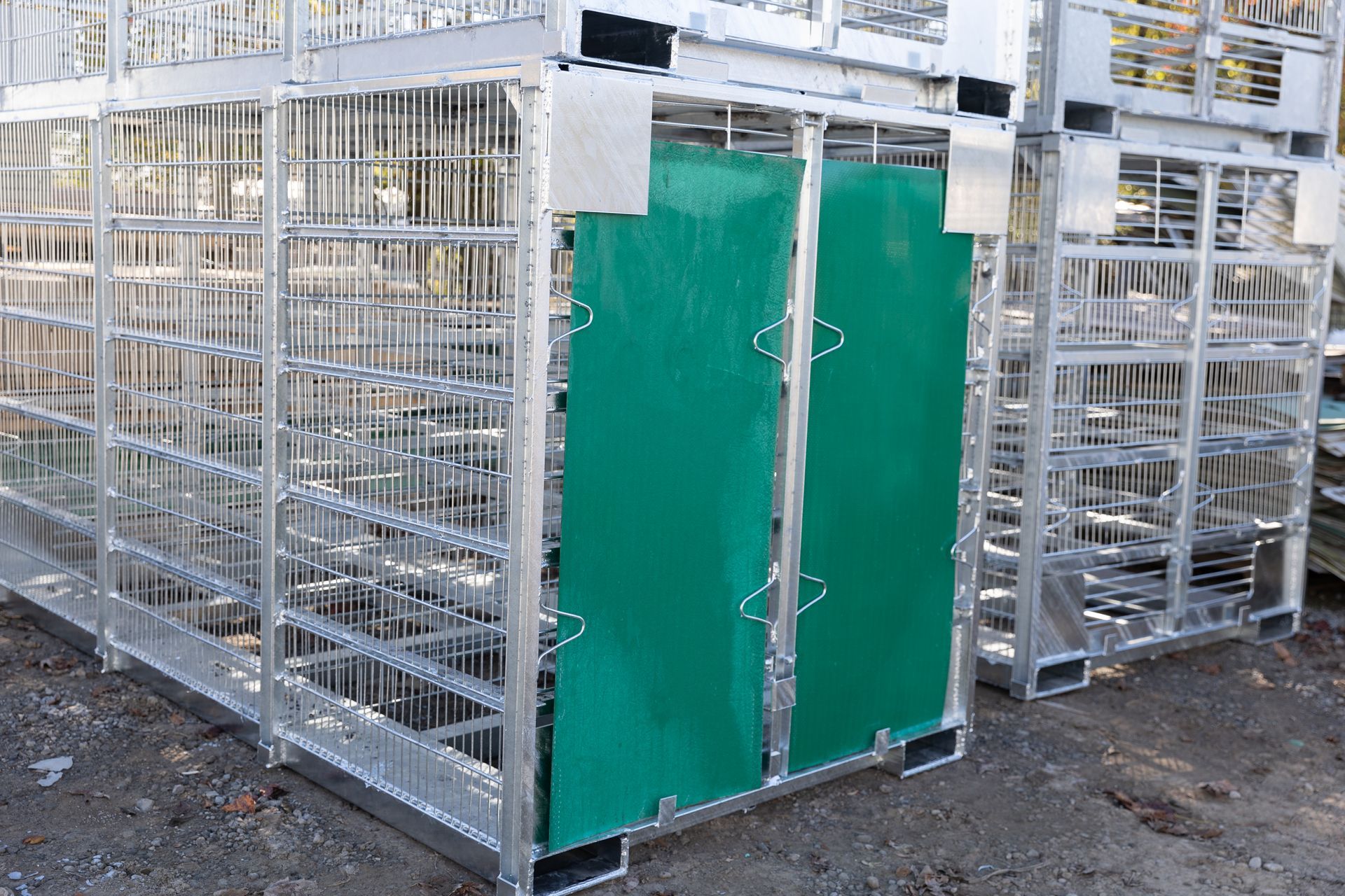 Metal storage containers stacked with green plastic panels.
