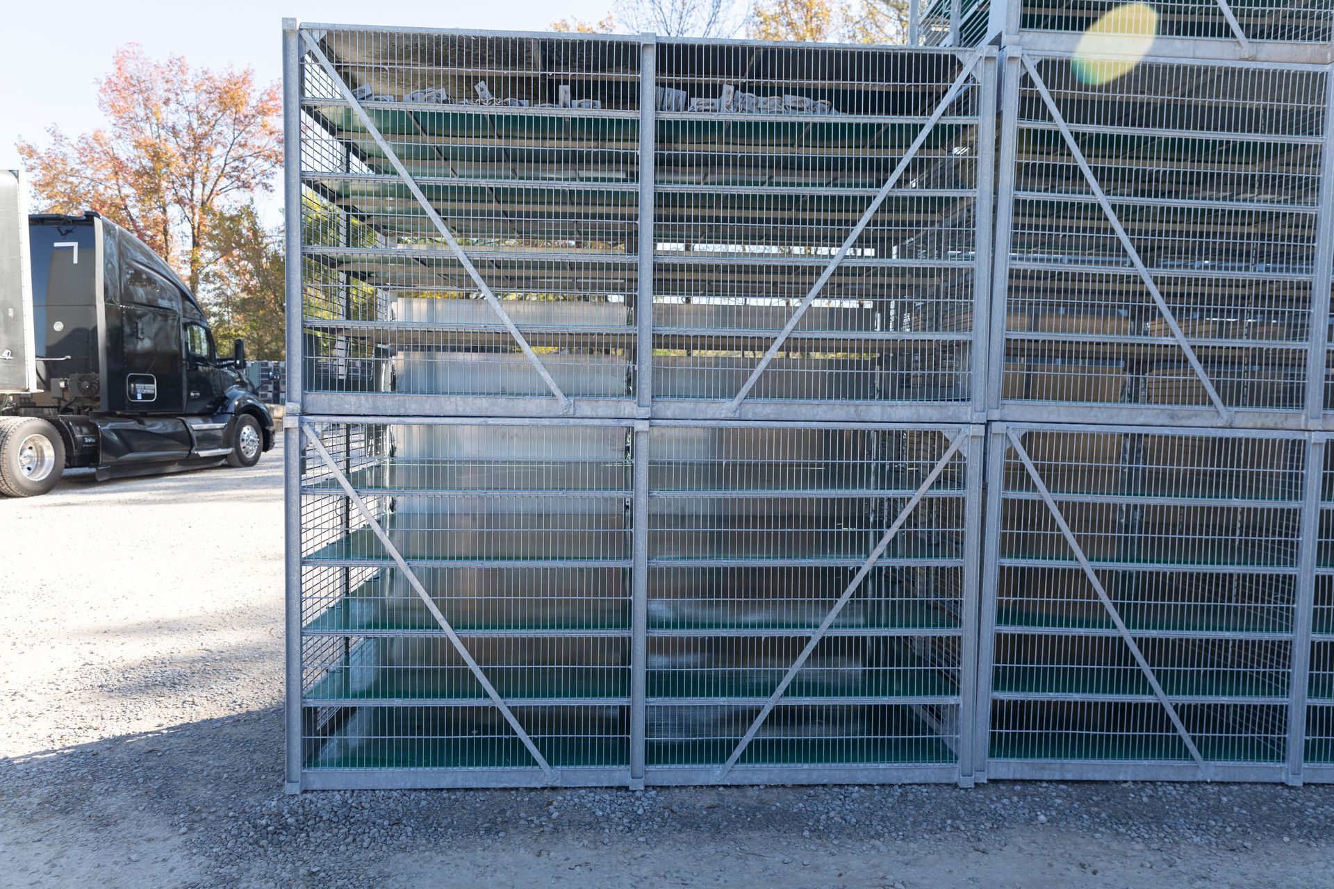 Metal structure with many vertical and horizontal bars; view through the bars of a water-filled container.