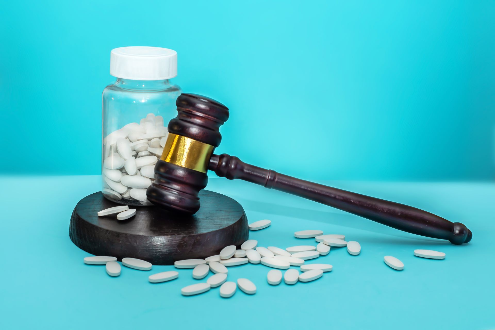 Gavel leaning on pill bottle.