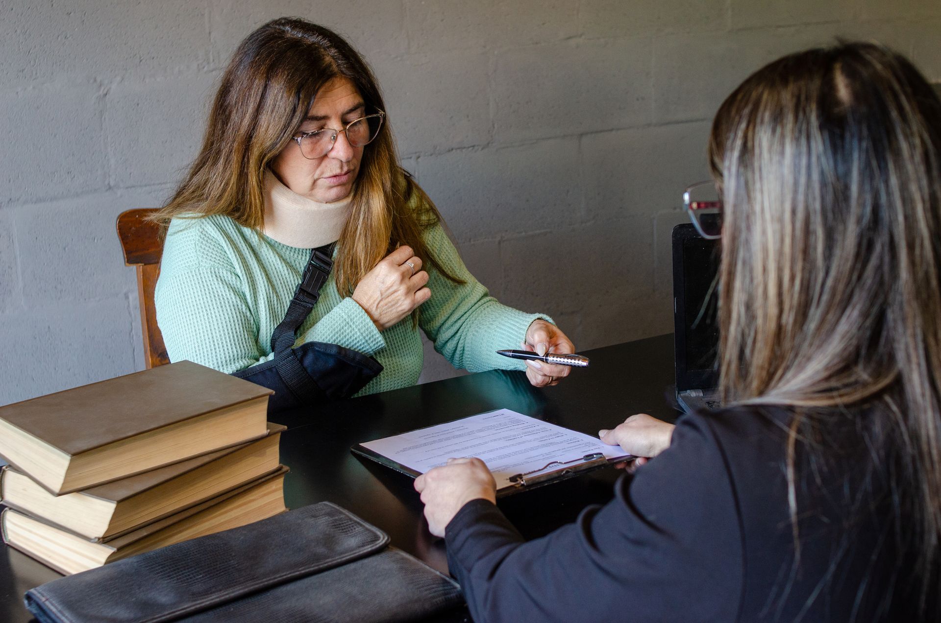 Female attorney explains legal documents to an injured client during a consultation.