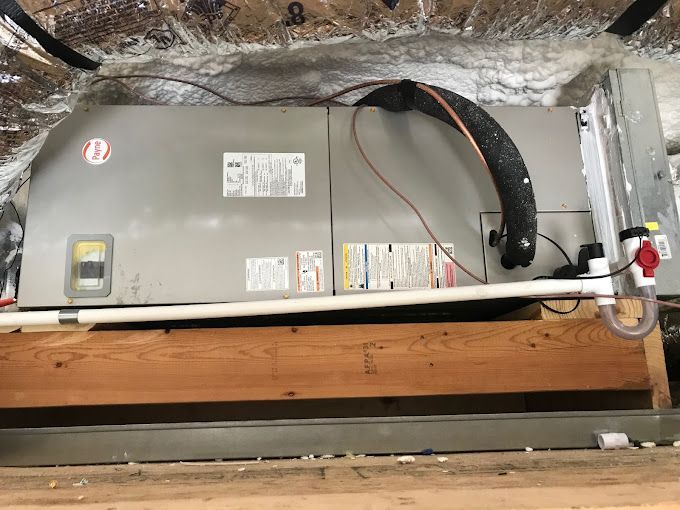 A ceiling mounted air conditioner is sitting on top of a wooden table.