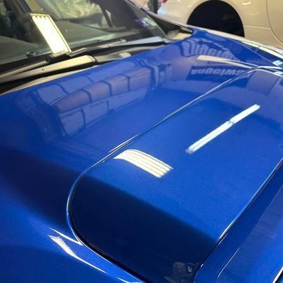 a close up of the hood of a blue car