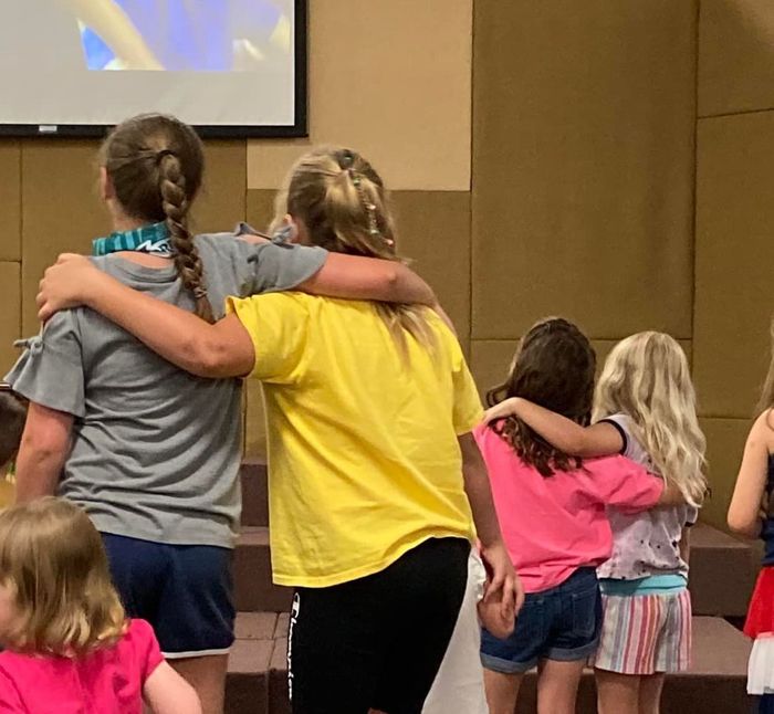 Image of youth with arms around others' shouldters