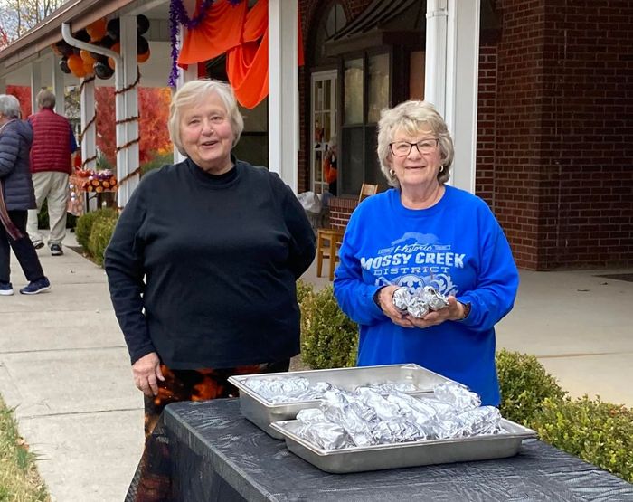 Image of 2 women offering food