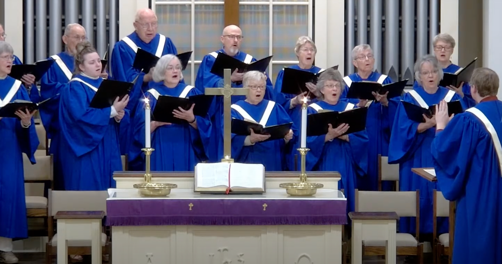 A choir is singing in front of an altar in a church.