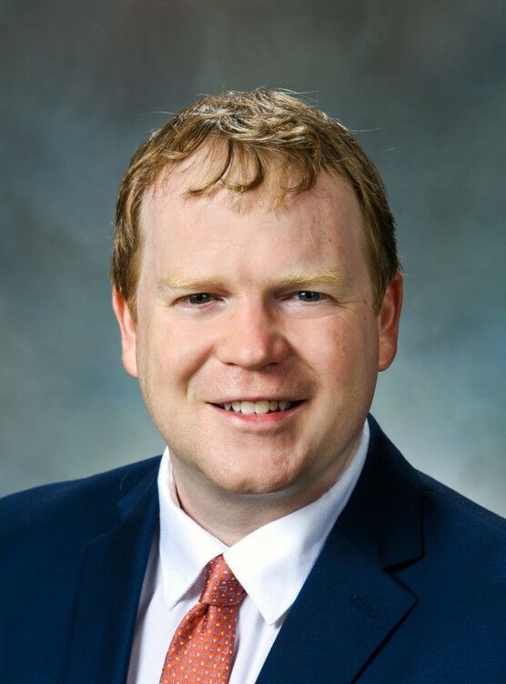 A man in a suit and tie is smiling for the camera
