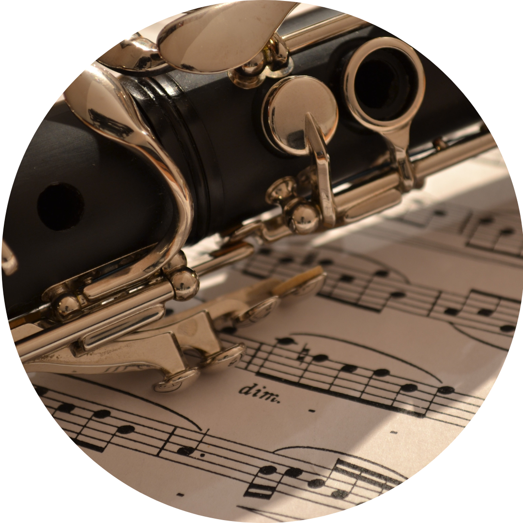 A close up of a clarinet on top of sheet music