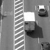 A black and white photo of a truck driving down a highway.