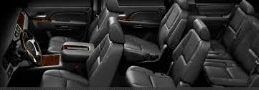 Interior view of a vehicle with black leather seating, including front bucket seats and rear bench seats.