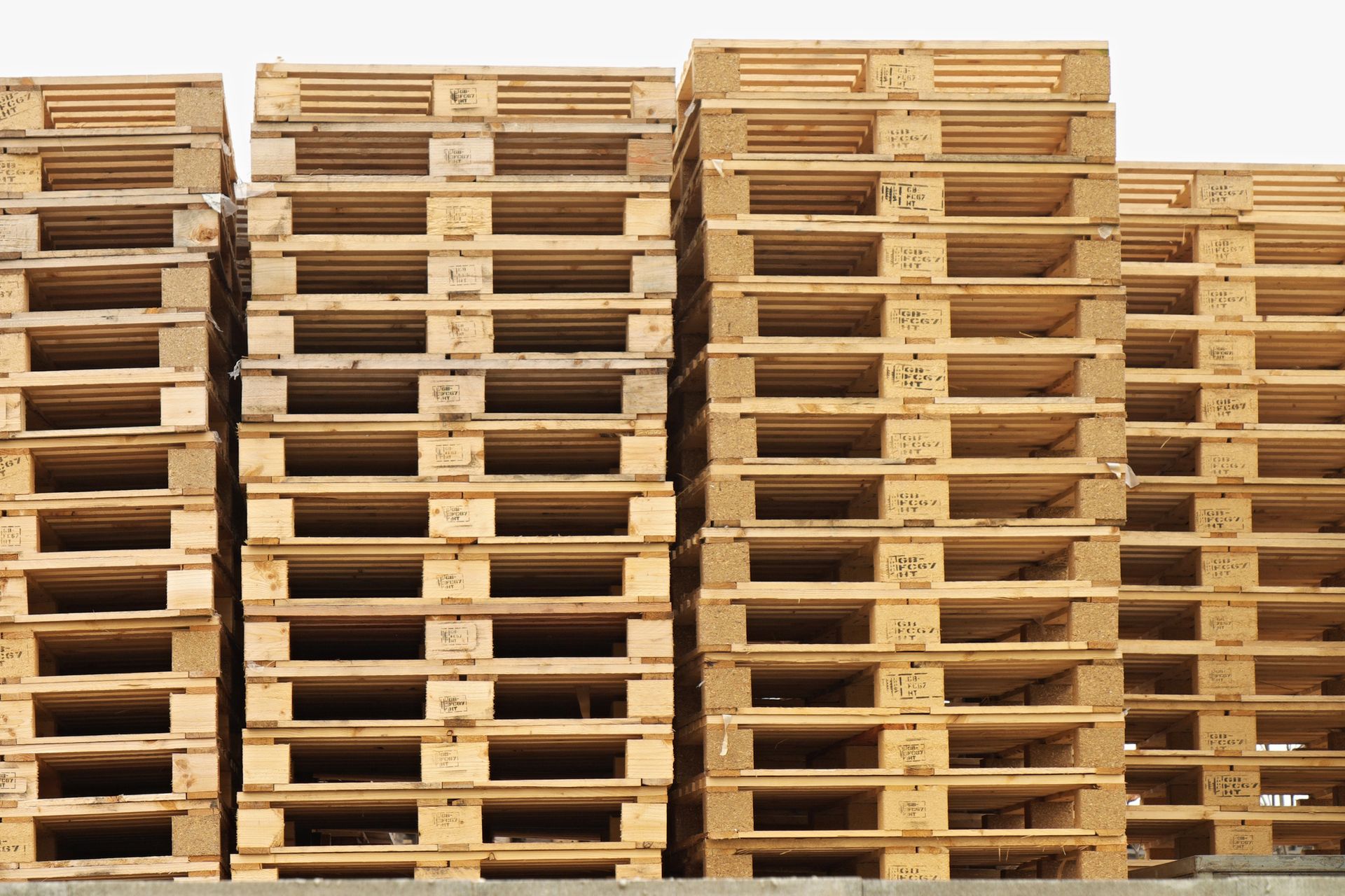 Una pila di pallet di legno appoggiati uno sopra l'altro sul terreno.