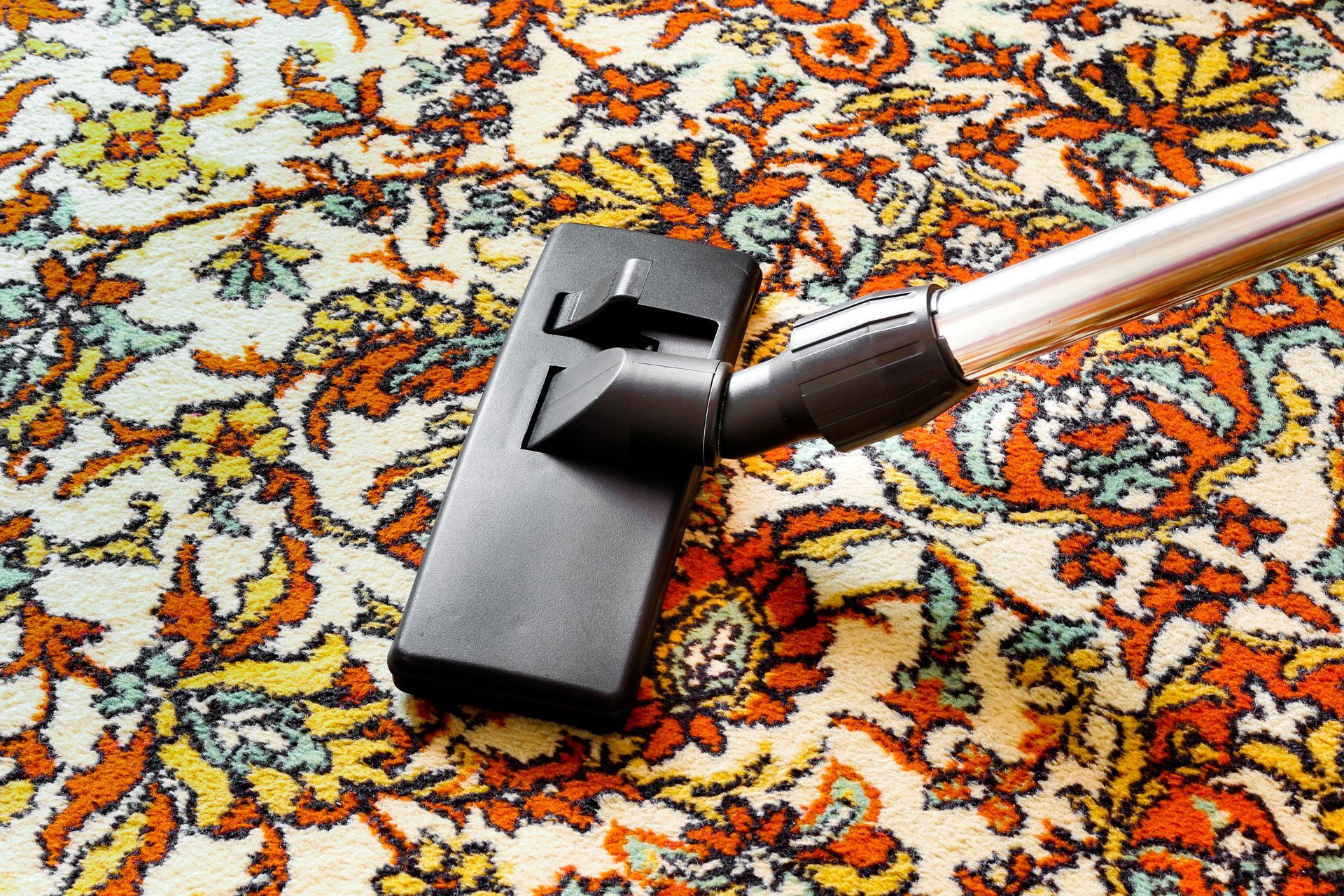 Vacuum cleaner head on a colorful patterned rug