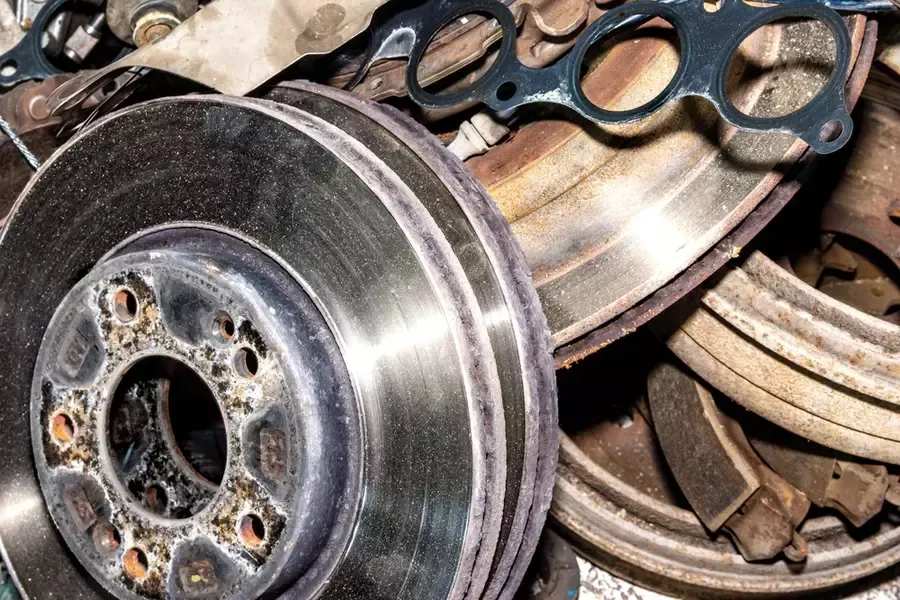 A pile of discarded brake components consisting of OEM and aftermarket parts.