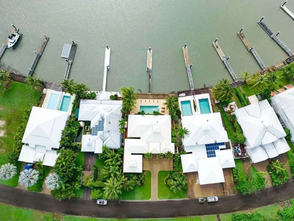 Aerial View of Waterfront Homes With Docks and Pools, Lined Up Along a Waterway — MDSR Group In Manunda, QLD