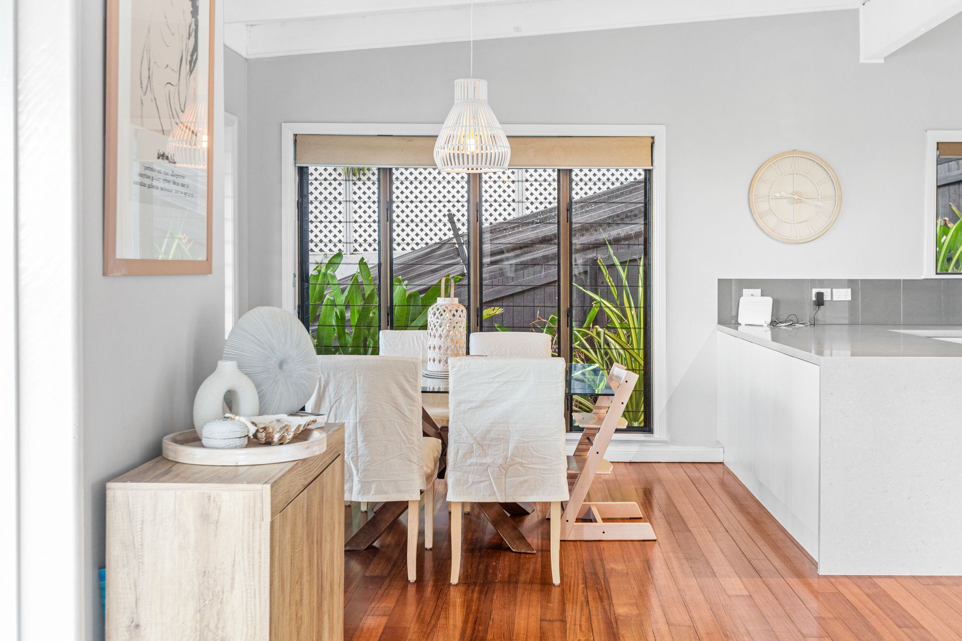 Dining Room With a Wooden Table, Chairs, and Light Fixture — MDSR Group In Manunda, QLD