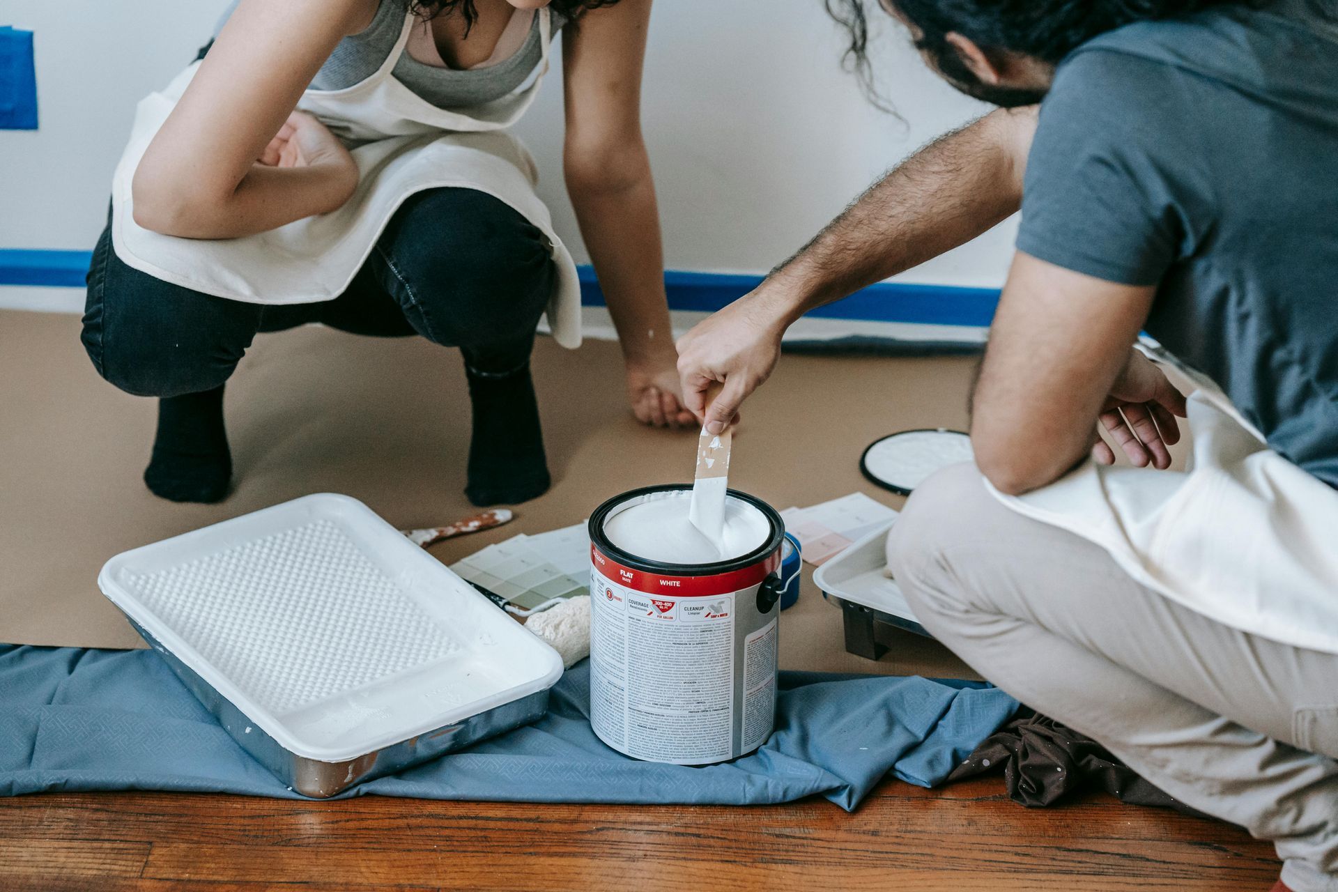 Open Paint Cans With a Wooden Brush Resting on Top — MDSR Group In Manunda, QLD