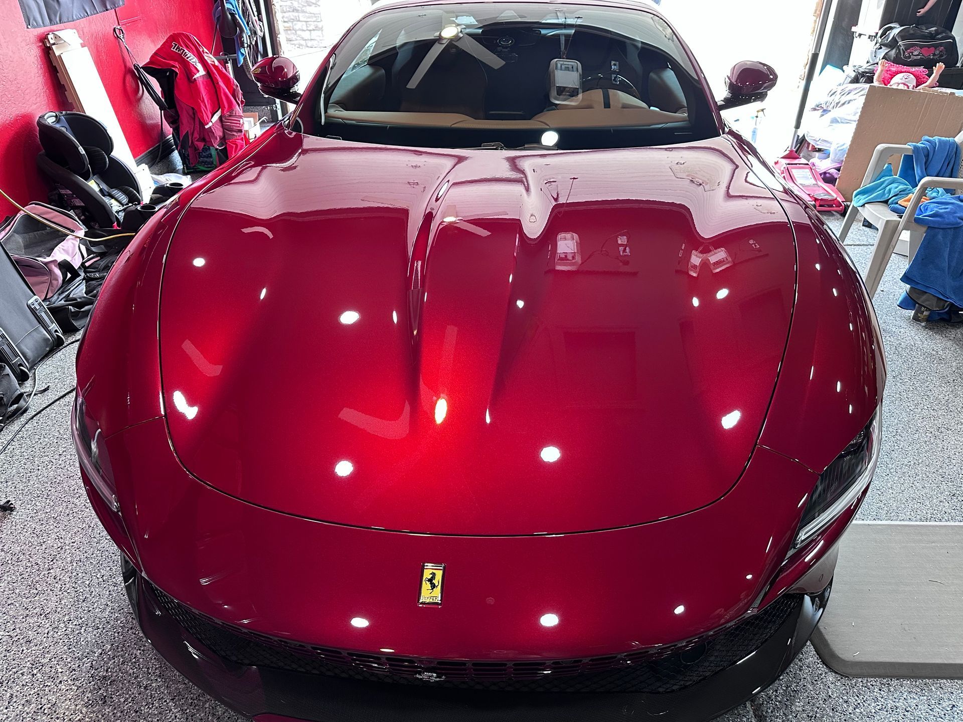 A red ferrari is parked in a garage.